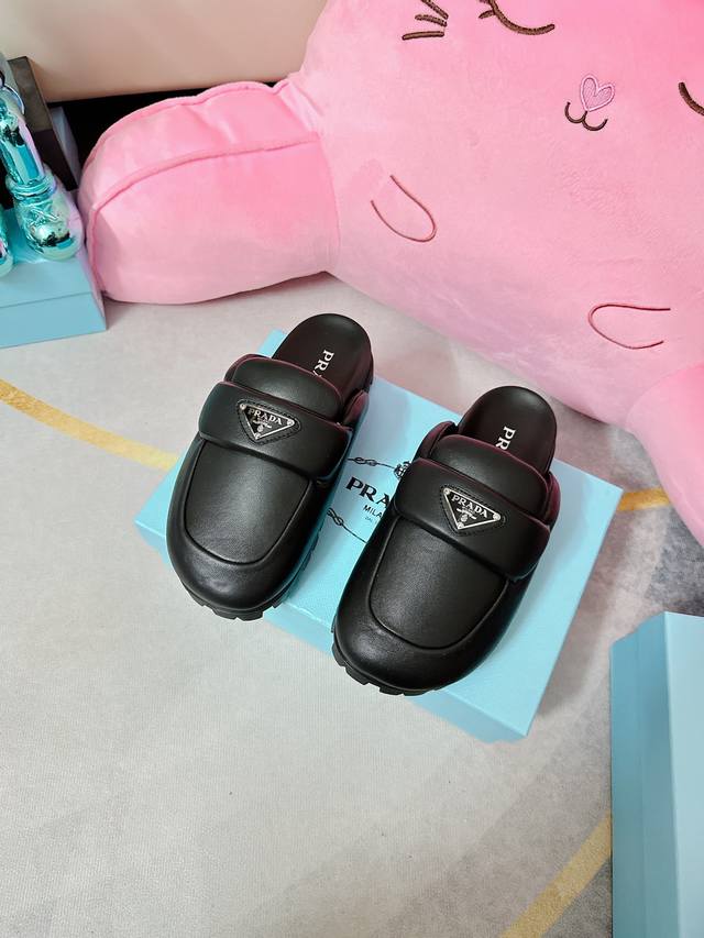 Prada 普拉达 2023最新 穆勒鞋 这双穆勒鞋是泡沫底 很轻便 Prada标志性的珐琅三角标辨识度也很高 黑色也很百搭 Prada 还能出这么可爱的鞋真是