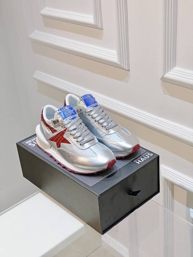 马拉松系列艺术家合作款运动系列 此款鞋子采用nappa皮革鞋面 搭配闪闪发亮的银色耐磨面料和红色闪光细节 鞋跟片添加3 D稳定器 增加了活力 并前所未有地突出了