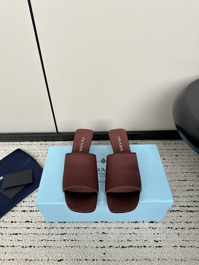 Prada 24Ss夏季新款一字缎面凉拖鞋 这款缎面凉拖鞋以现代主义线条和新颖的建筑感造型为特色，展现出精致优雅的魅力。Prad*三角形标志性的几何形状成为这款