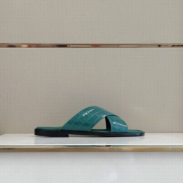 P家最新拖鞋官网同步-真皮大底 这款拖鞋以品牌独特的标志性saffiano牛皮打造，品牌徽标跃于双饰带，品牌格调一览无余。牛皮和真皮大底赋予男性优雅魅力与功能性